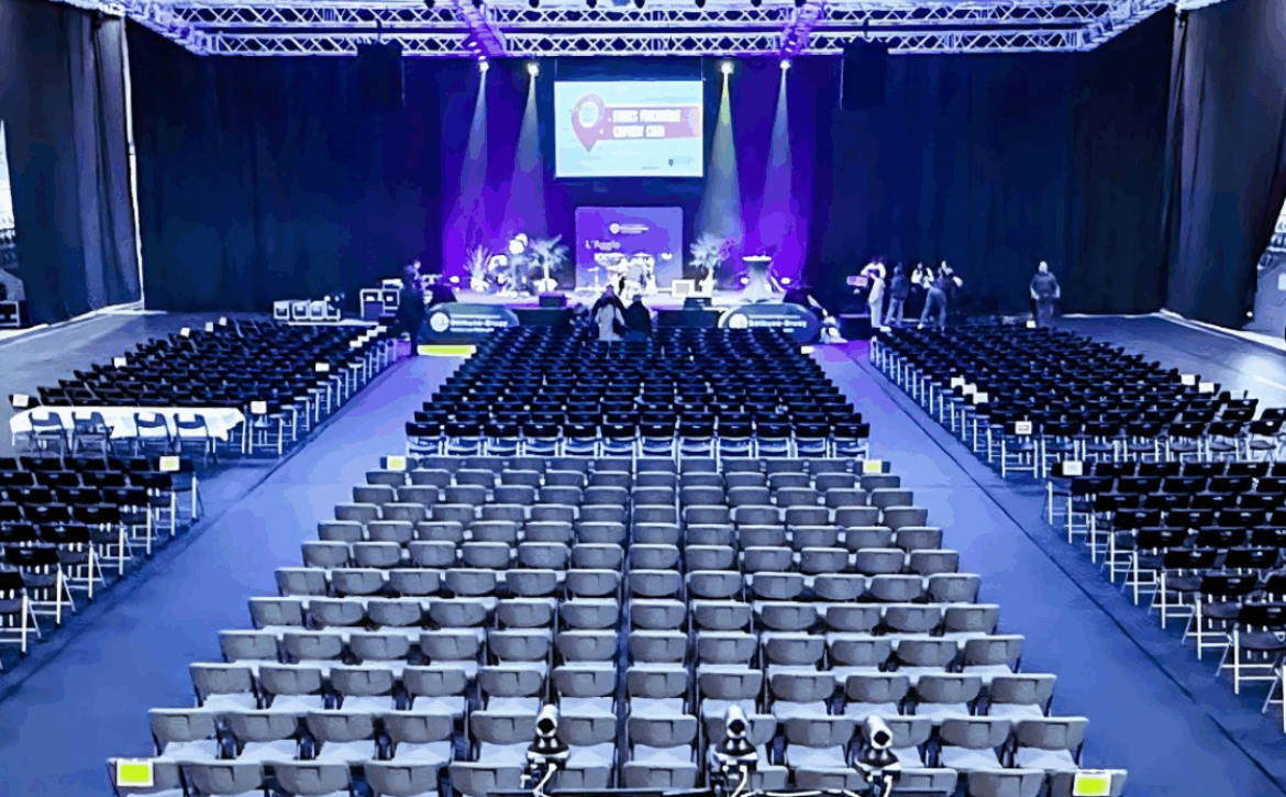 Salle de séminaire vide avec rangées de chaises, scène éclairée et écran, événement corporate Hauts-de-France - S'TORM EVENTS Béthune
